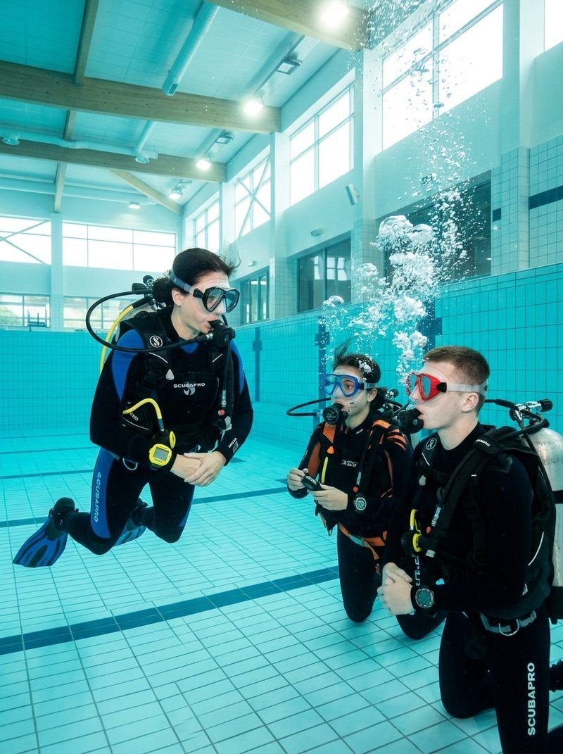 Scuba students practicing foundational regulator and mask skills during PADI pool training session in Raleigh