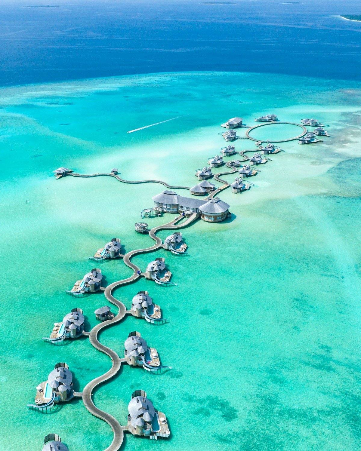 Couple relaxing on a tropical sandy beach with scuba masks and fins beside turquoise ocean water