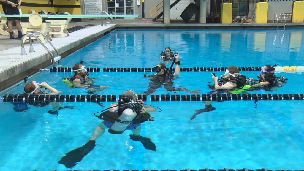 Person performing hamstring and back stretches on a floor mat to increase flexibility for scuba diving