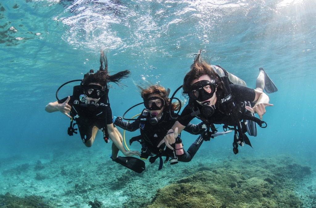 Discover Scuba student taking first breaths underwater from regulator during shallow heated pool training