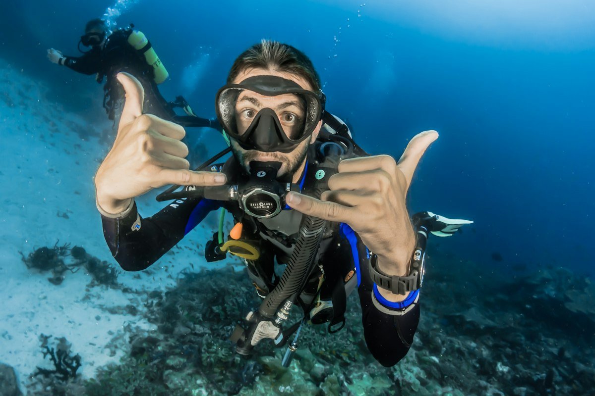 Scuba diver swimming with gentle fin kicks above fragile coral reef without touching marine life